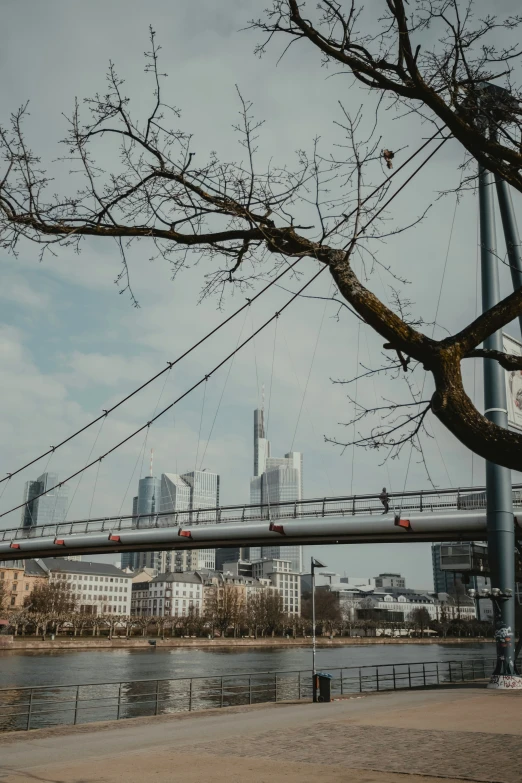 a bridge spanning over a body of water with some buildings in the background