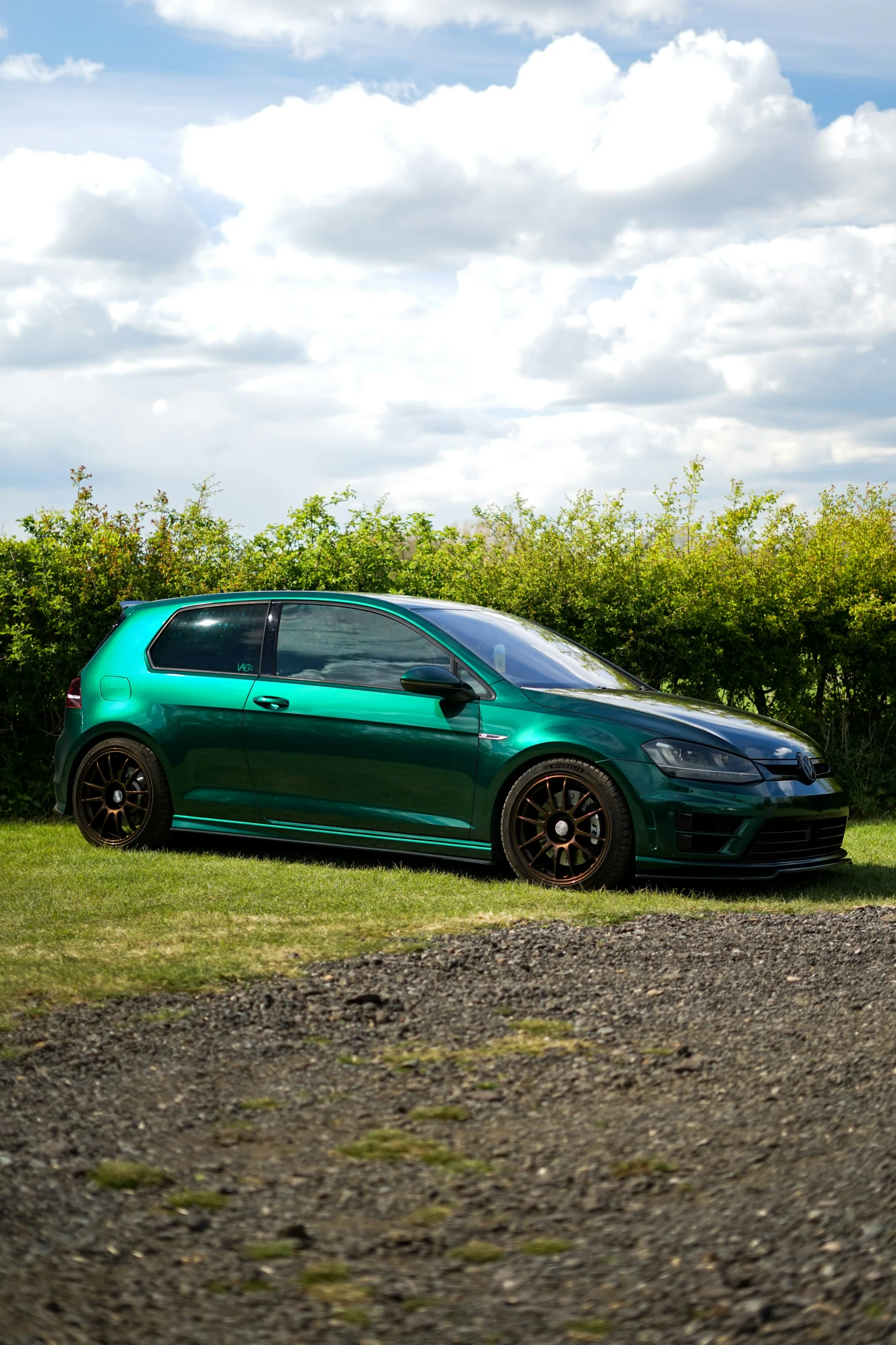 a green and black car parked in a grassy field