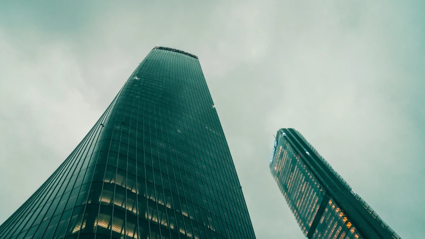 two tall skyscrs towering above a cloudy sky