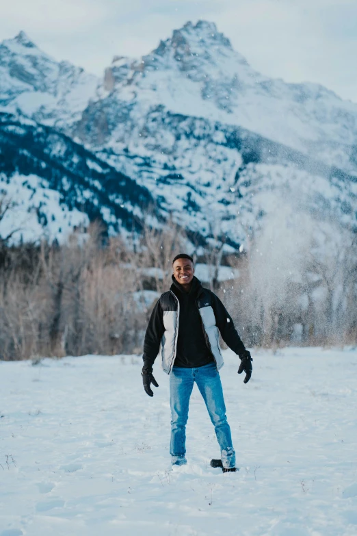 a man on snow skis standing in front of a mountain