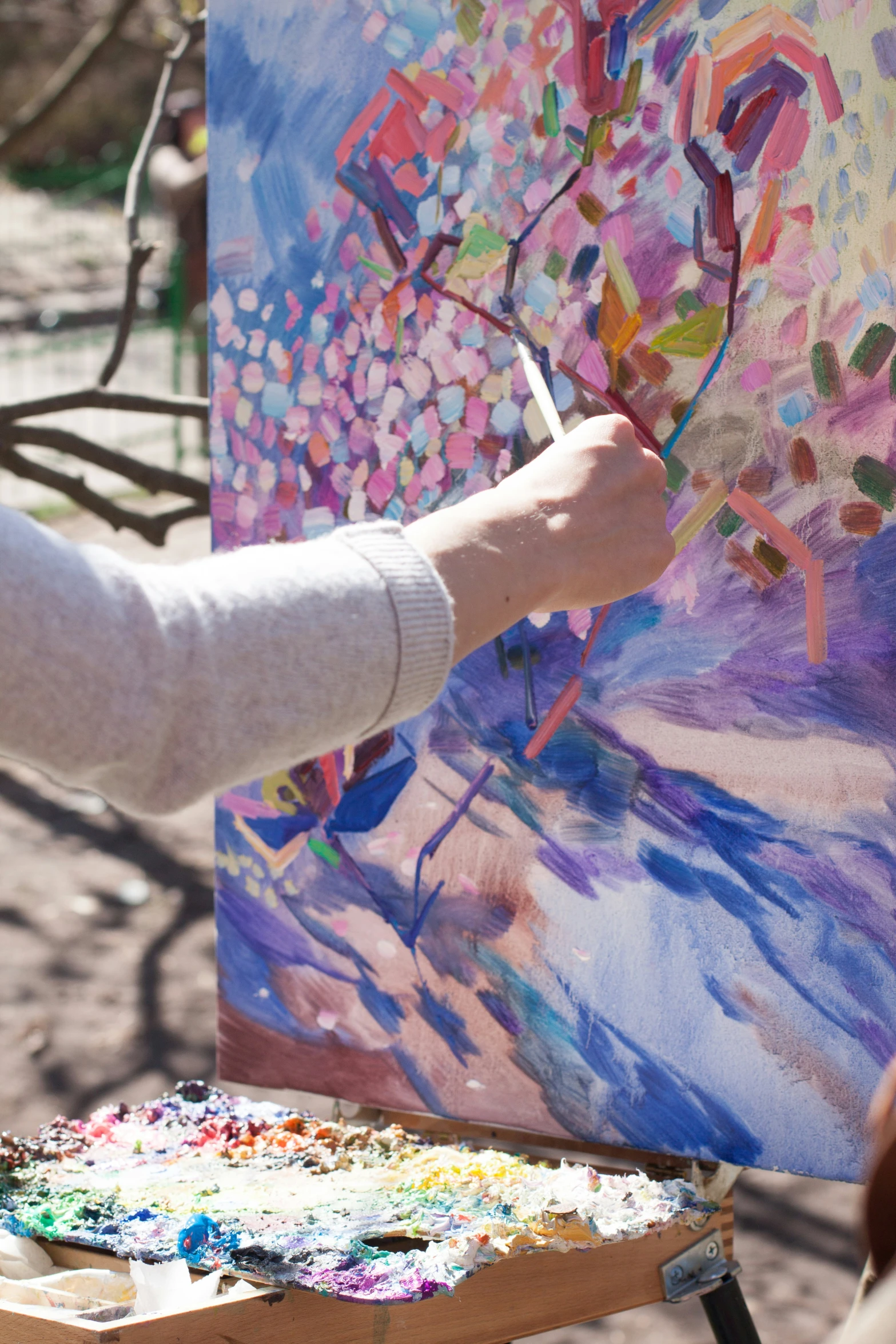 a woman painting in an art class outdoors