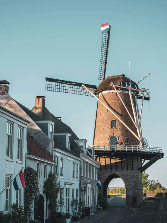 a tall windmill that is standing next to houses
