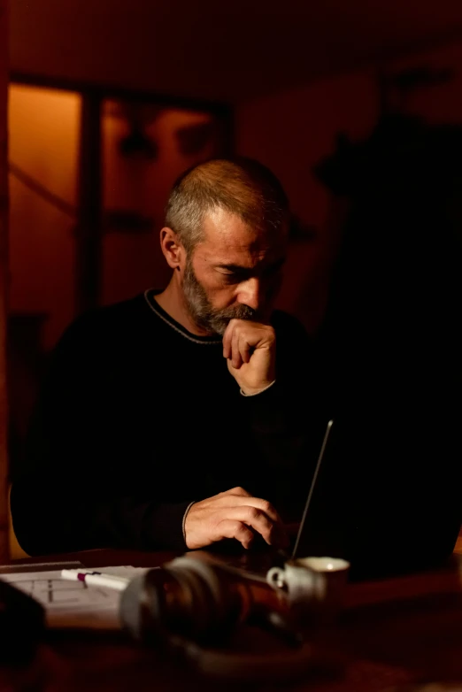 a man sitting with his head resting his chin in his hand