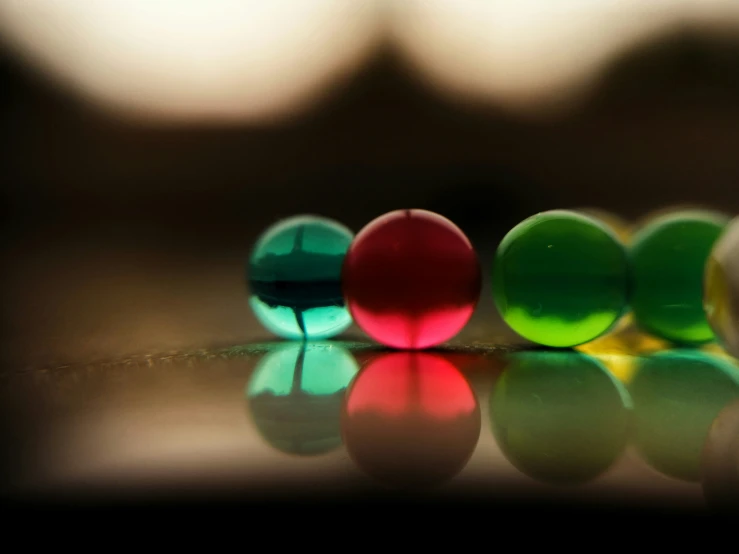 four bright green, orange and red balls sitting in front of each other