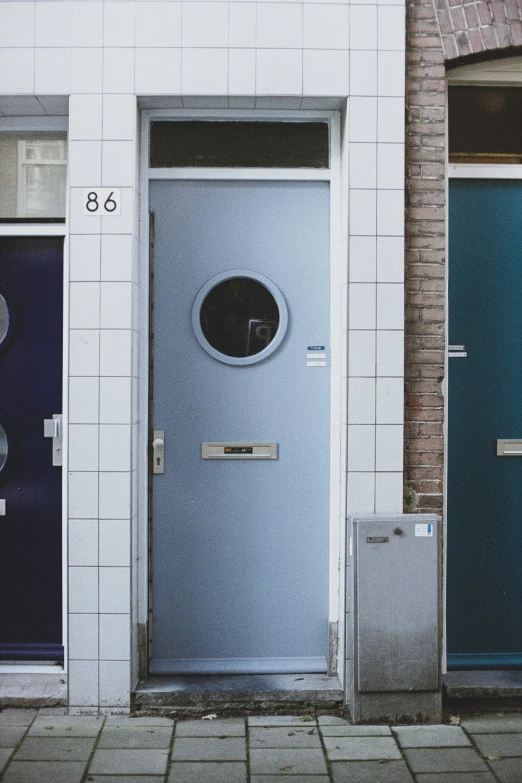 two blue door, one with a window on top and one with a round window