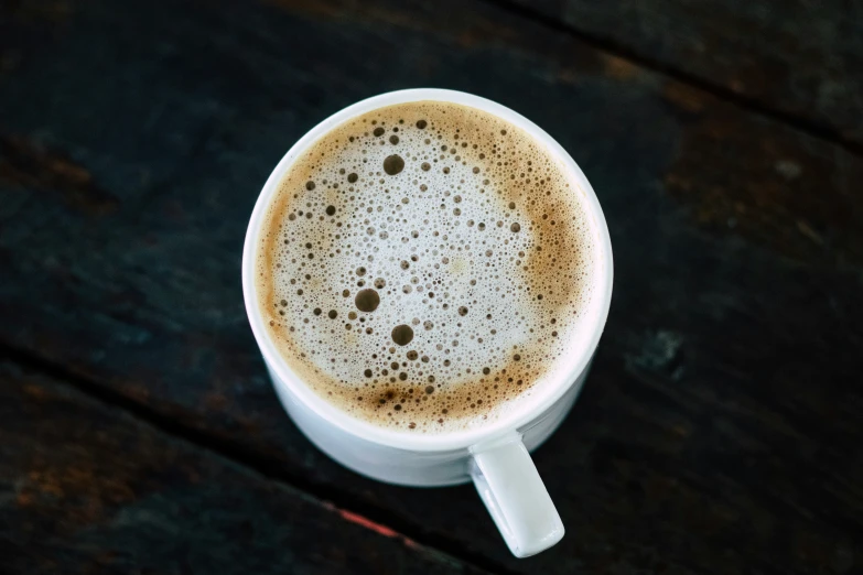 an espresso in a mug that is on a wooden table