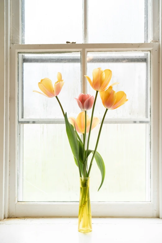 a vase filled with pink and yellow flowers