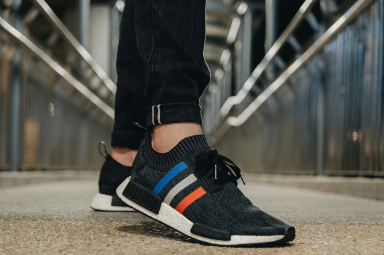 someone wearing a pair of black, orange, and blue sneakers