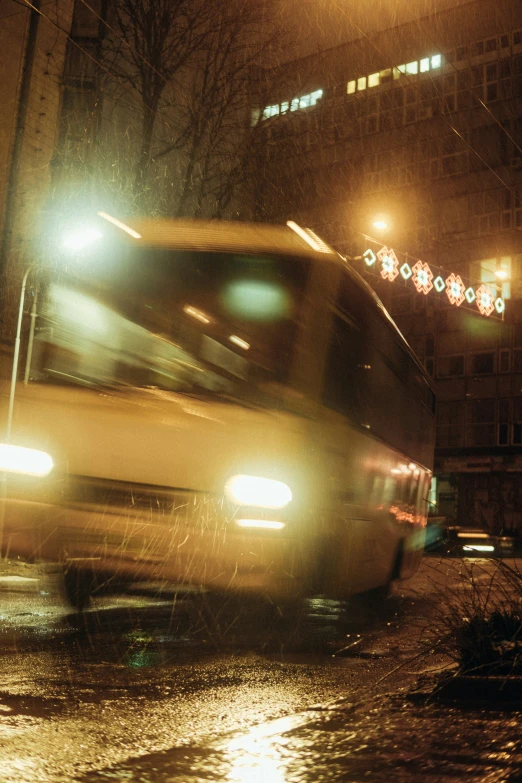 a big city bus drives down the street at night