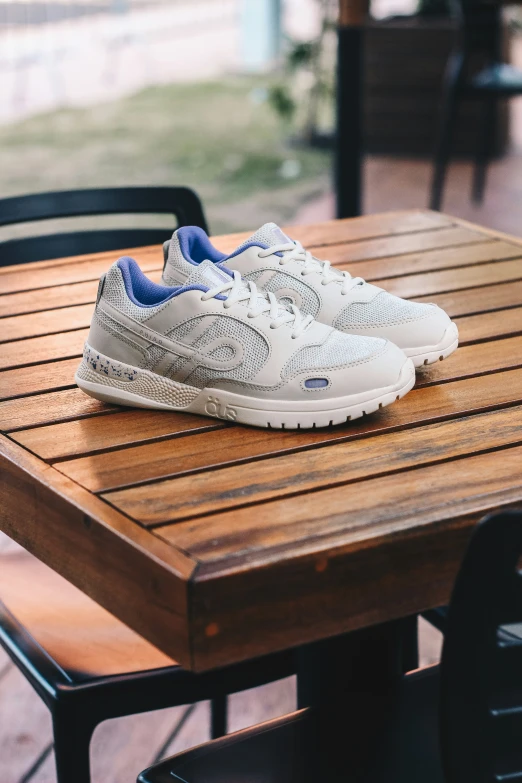 a pair of white shoes are on a wooden table