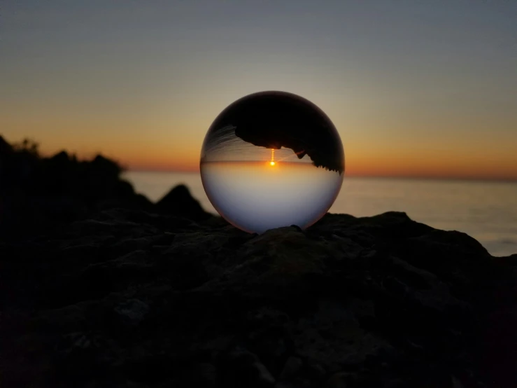 an image of sunset through a glass sphere