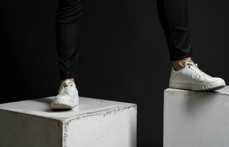 someone is standing on a box that also has a pair of white sneakers