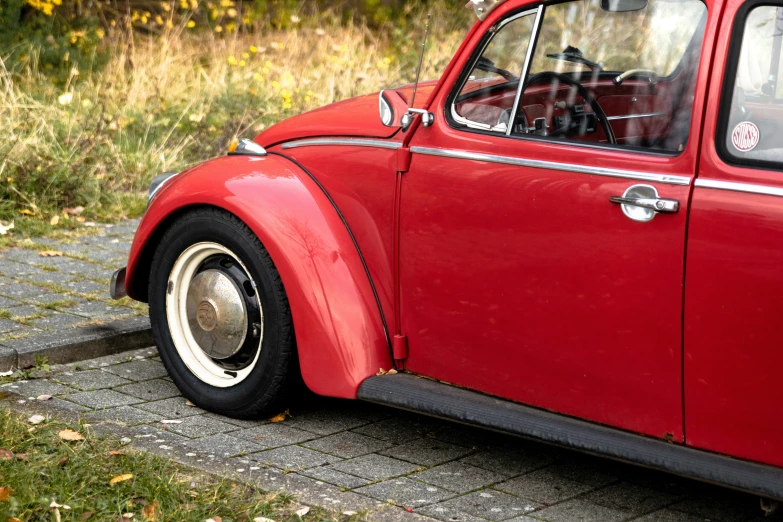 an old red car parked on the side of a road