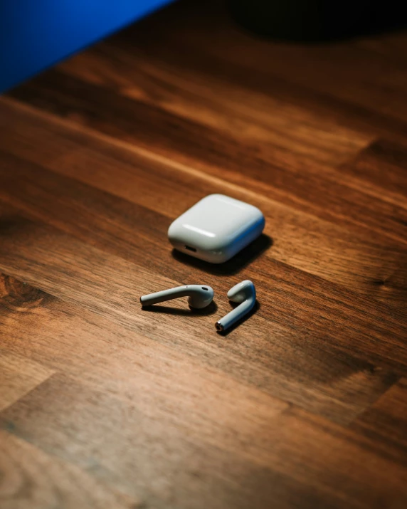 a cellphone sits on a wooden table next to several other pieces