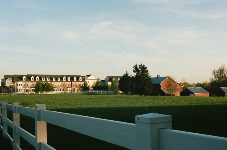 a large house on a nice looking lot next to a white fence