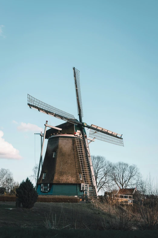 windmill stands next to a path across an open field