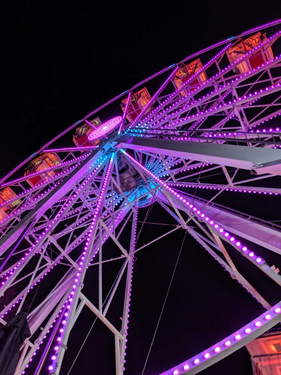 purple light up lights in front of a ferris wheel