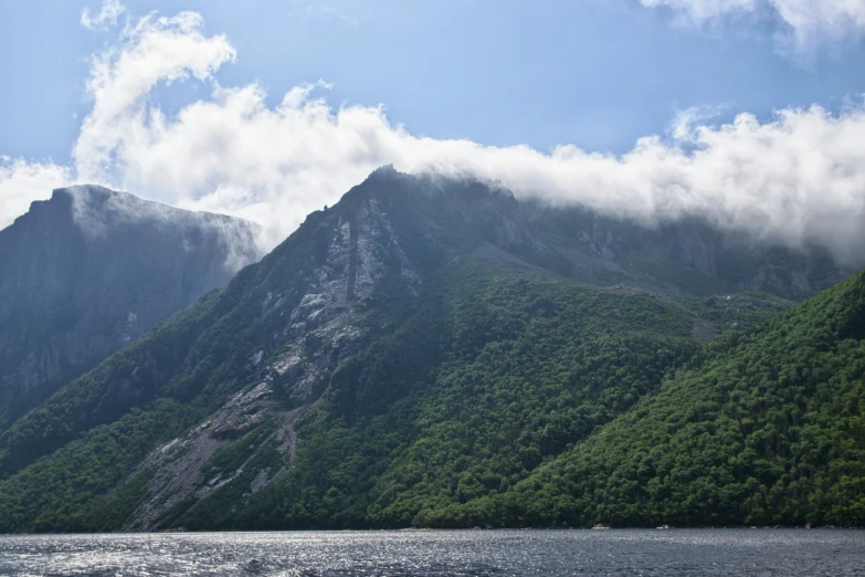 a body of water near mountains on a cloudy day