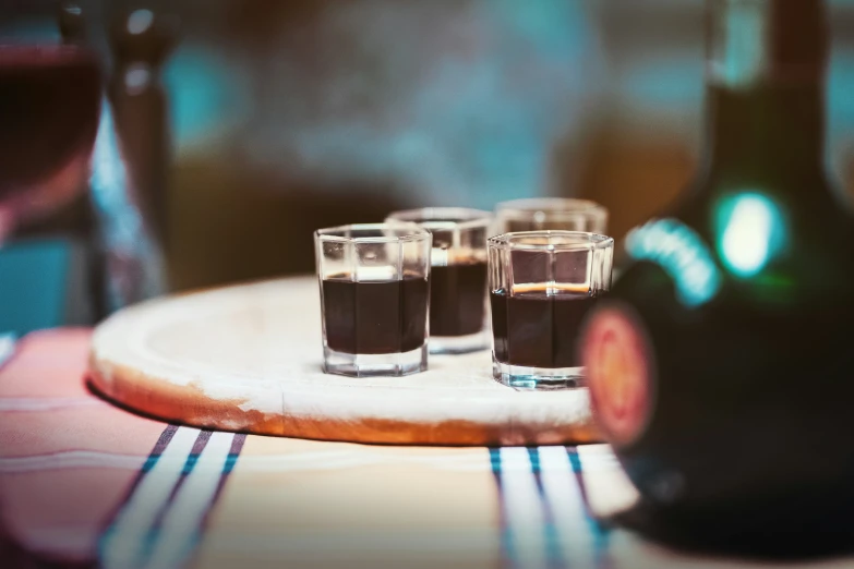 some ss in glasses sit on a wooden table