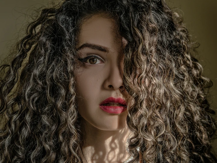 a young woman has curly hair and red lips