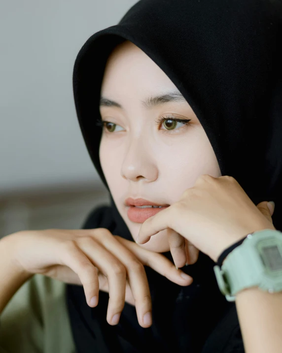a woman wearing a black hijab and watch