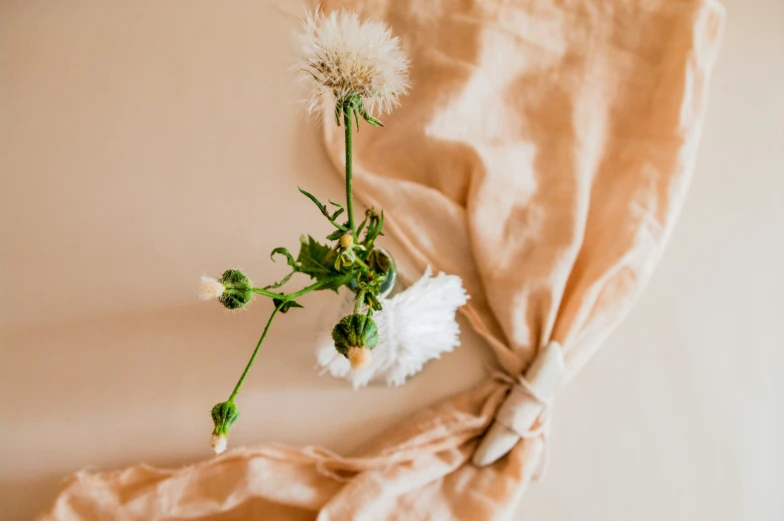 a flower is tied up to a bed sheet