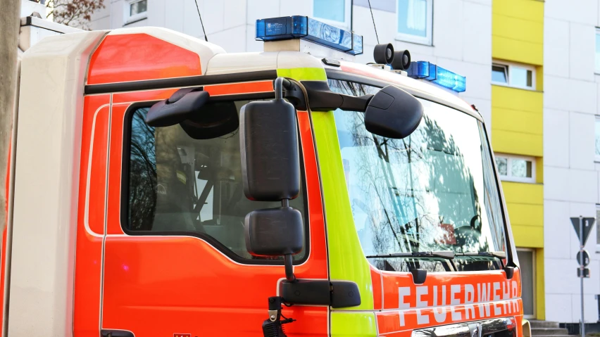 a large orange and white truck parked in front of a building