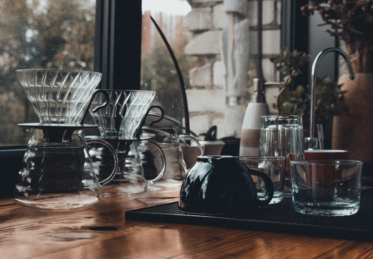 an assortment of coffee cups and glasses on a table