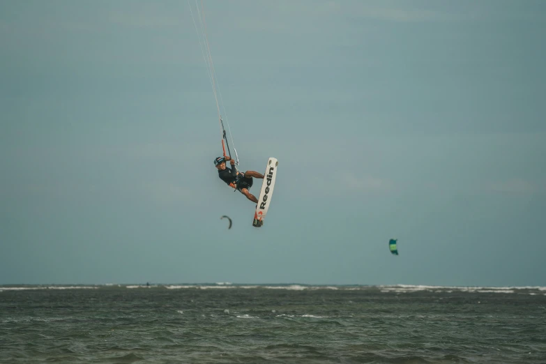 a person riding a kiteboard in the air over water