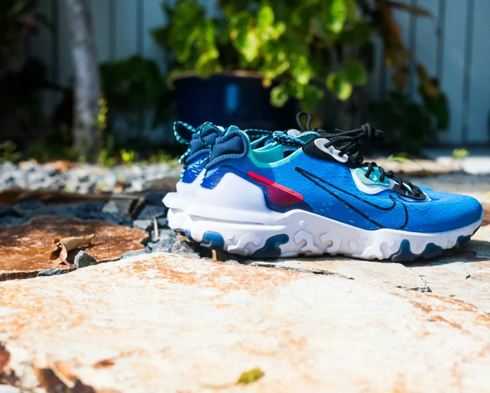 a pair of blue shoes sitting on top of some dirt