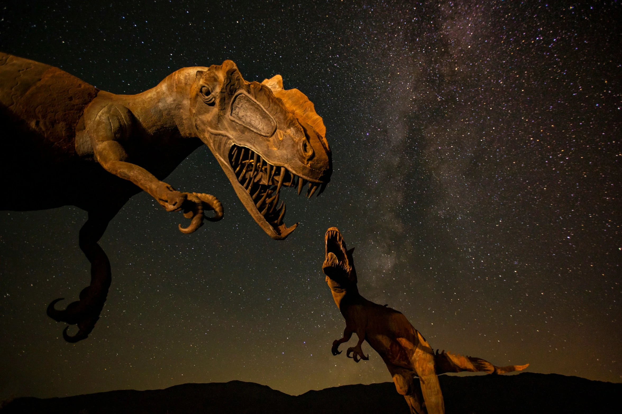 two dinosaur standing next to each other in the night