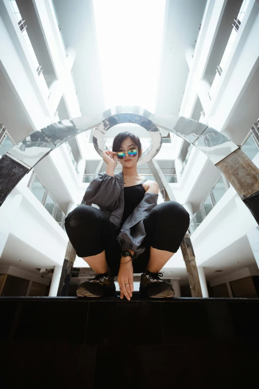 a woman sitting on a ledge while holding her cell phone