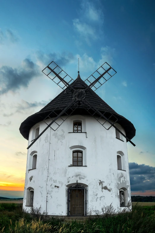 an old, rustic windmill sits in the middle of a field