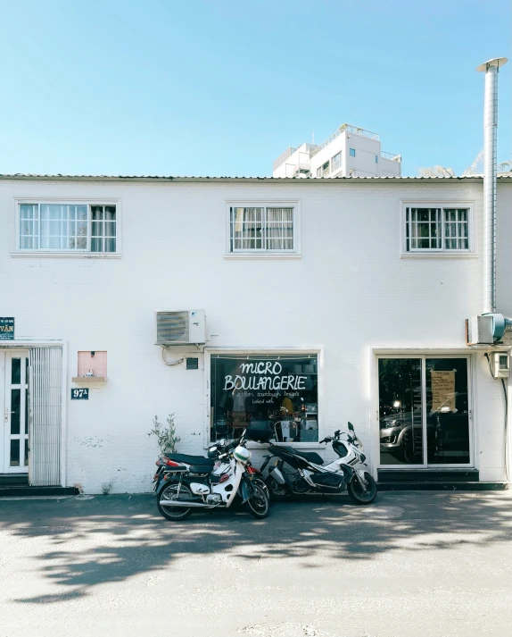 motorcycles sit outside the front of a building