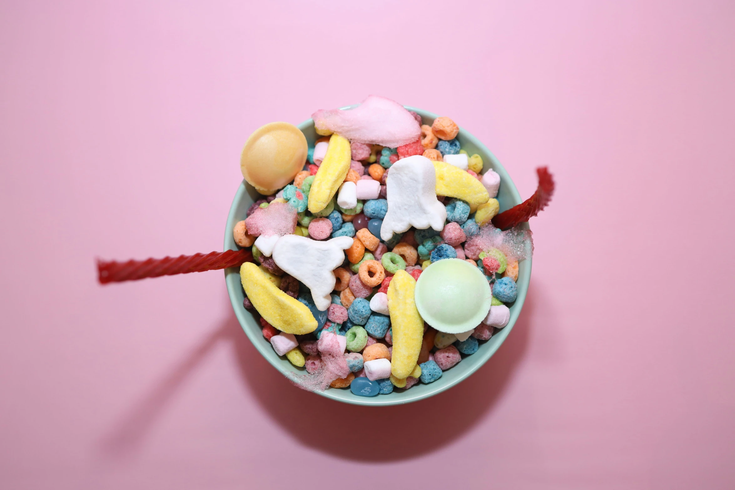 a bowl of cereal and ice cream on a pink surface