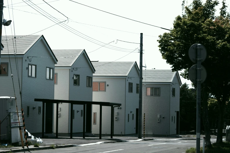 three row houses, some black and white, on the corner of a street