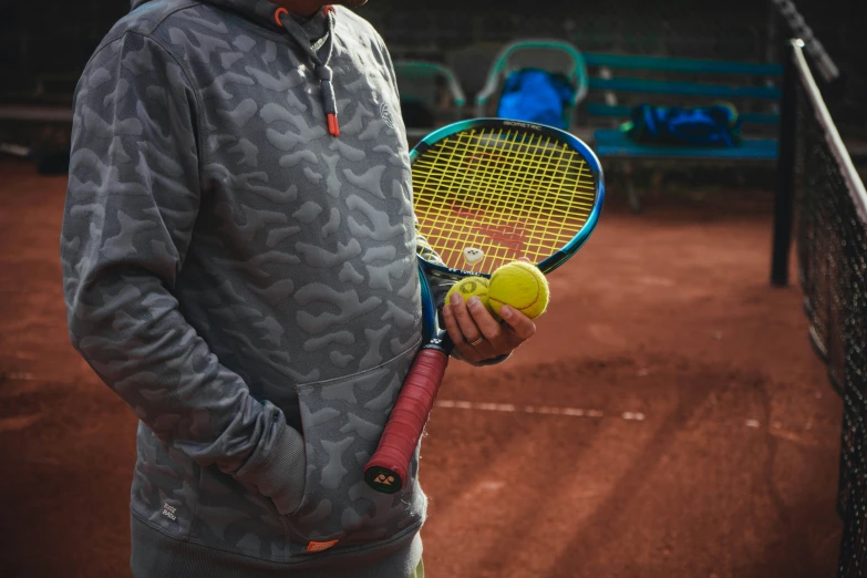 a man is holding his tennis ball and racket on a court