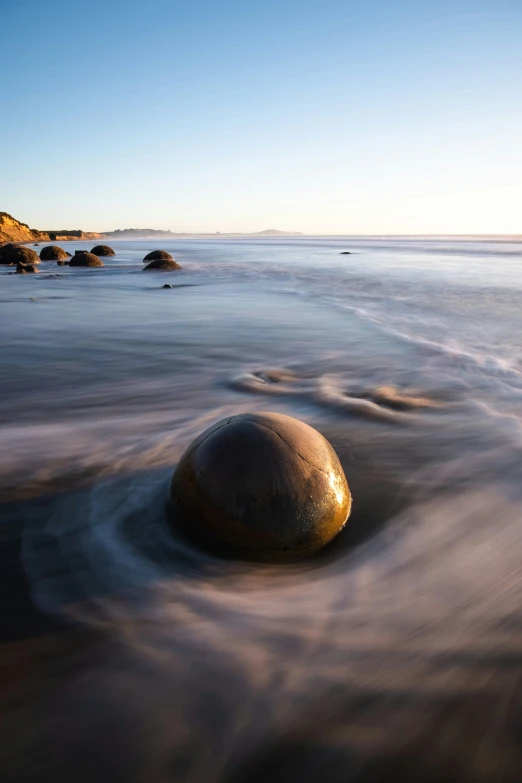 a large rock with its wavy formations on the beach