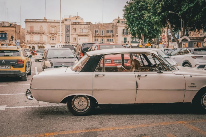 vintage car on a street near a busy city intersection