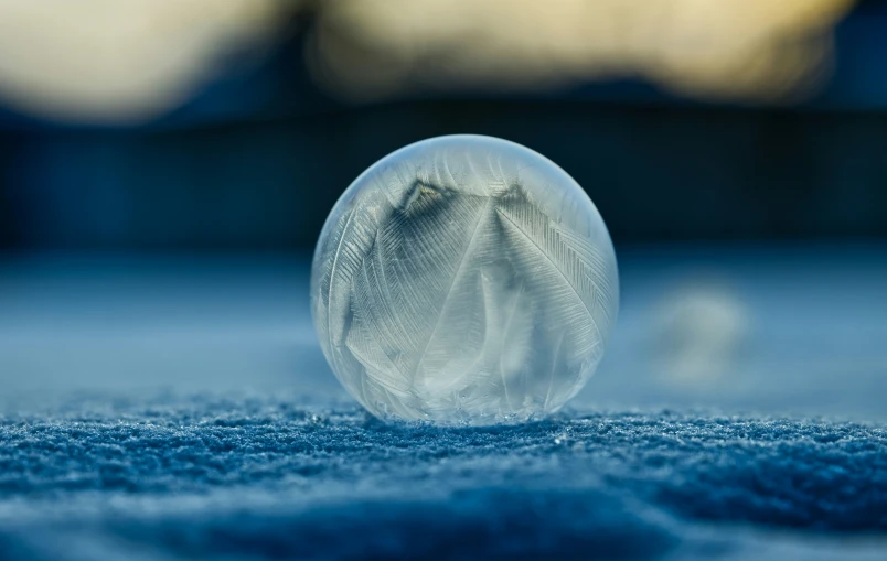 close up of a round glass object sitting on top of blue carpet