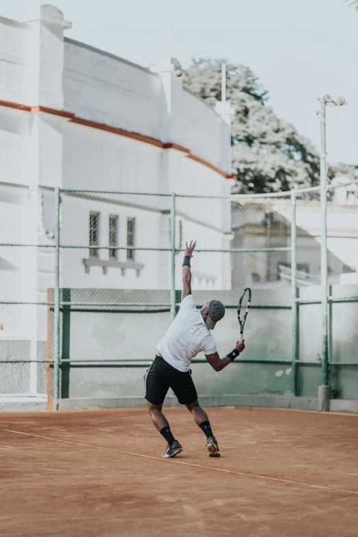 a man is reaching in the air to hit a ball