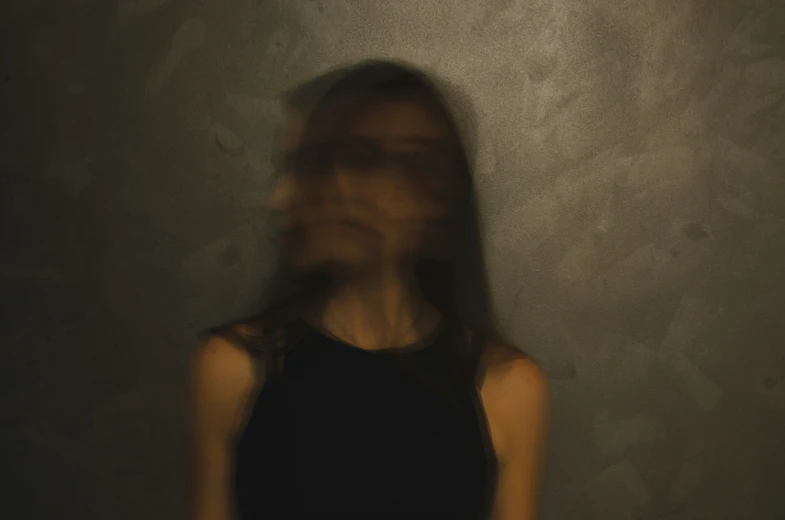 woman looking down in darkness while she holds a phone up