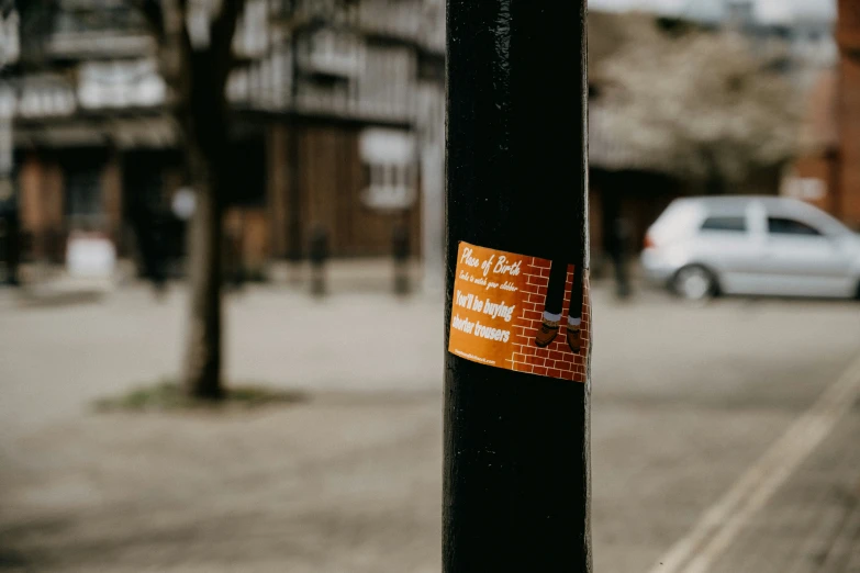 an orange sign stating street name on a pole