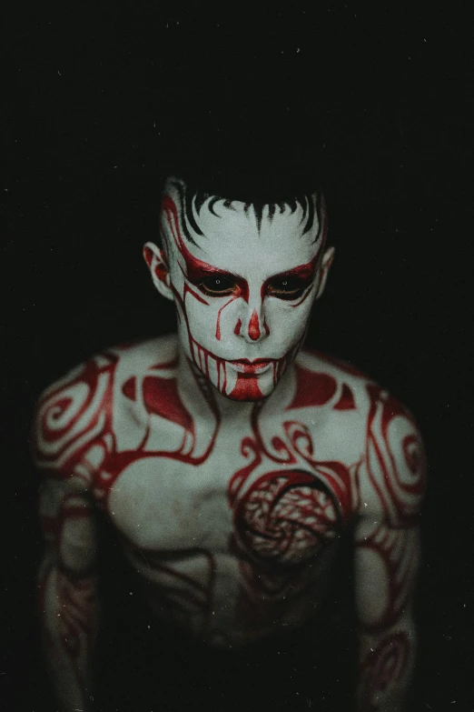 a man with a face makeup painted red and white