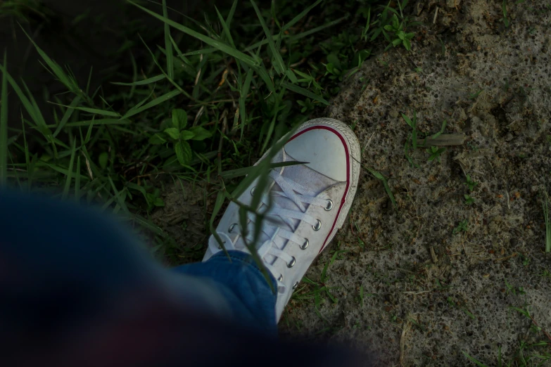 someone wearing tennis shoes standing on the ground