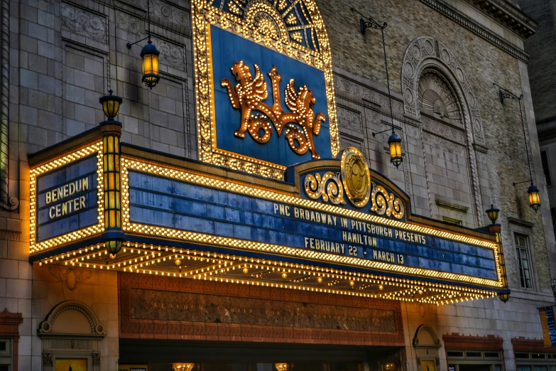an ornate theater sign in front of a large building