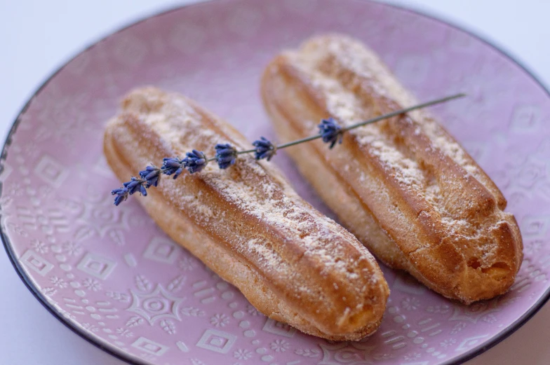 two small corn dogs are on a purple plate