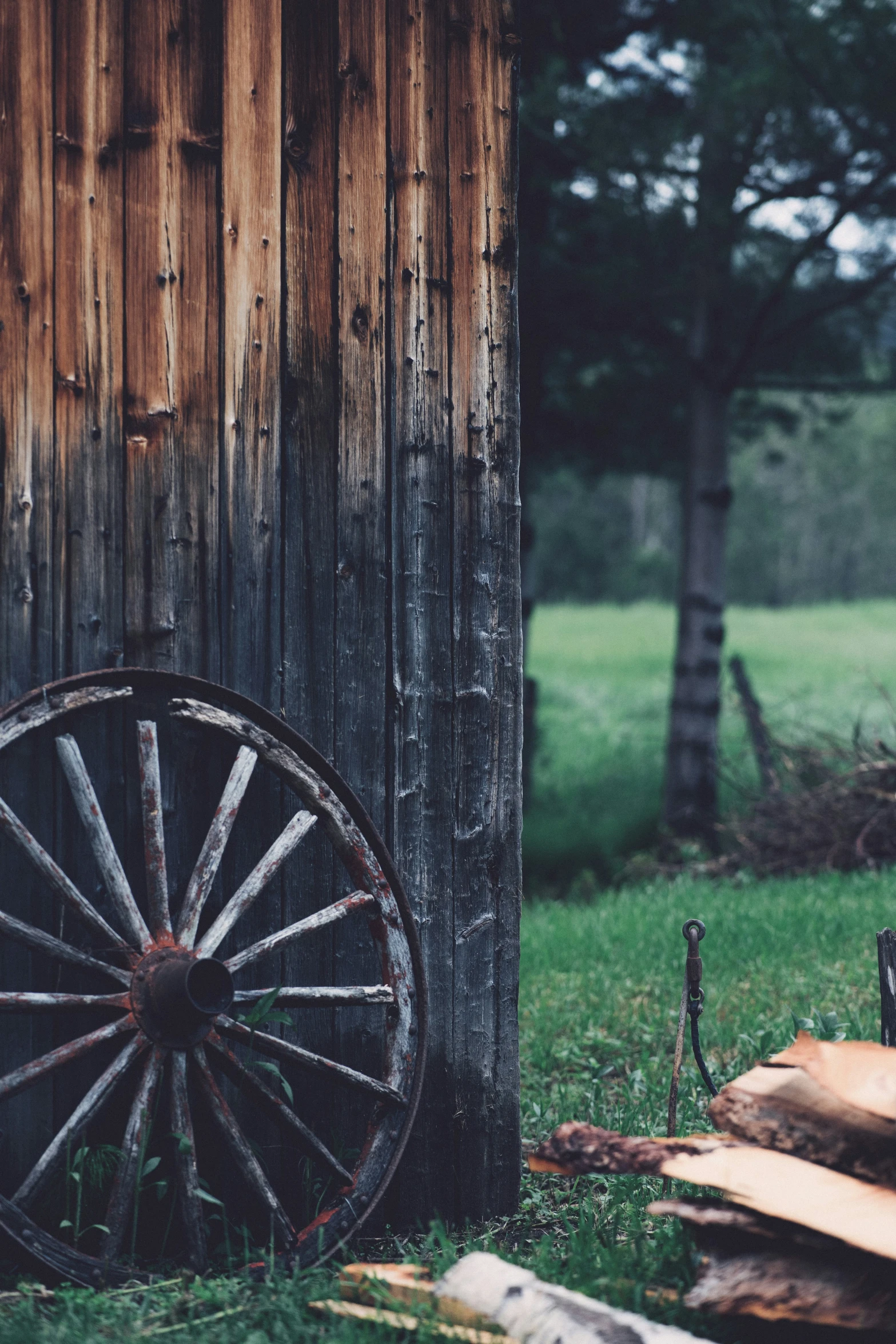 there is an old wooden wheel by a cabin