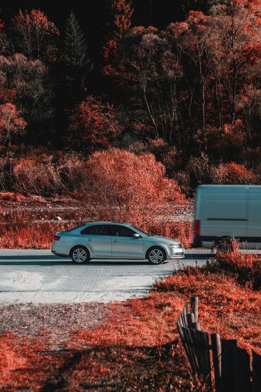 a car parked next to a truck in the woods