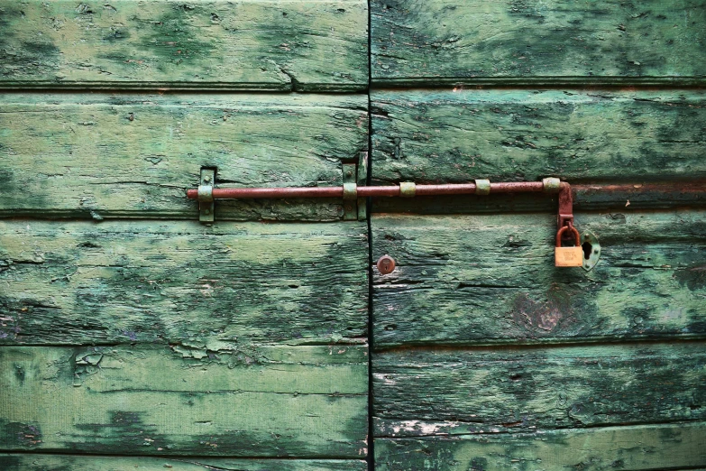 an old wooden shed is painted green